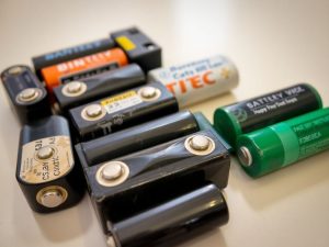 Baterii uzate, pregătite pentru reciclare, pe un fundal neutru.